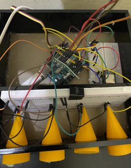 Inside the enclosure: an Arduino and breadboard wired to a load cell, with the four yellow printed button caps below.