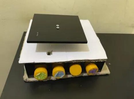The finished kitchen scale: a white weighing plate over a black enclosure, with four large yellow textured buttons along the front edge.