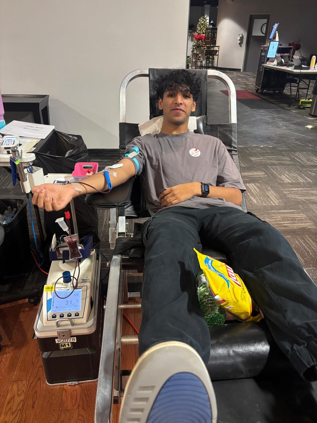 Sitting in a donation chair with a line in one arm and the machine running beside it.