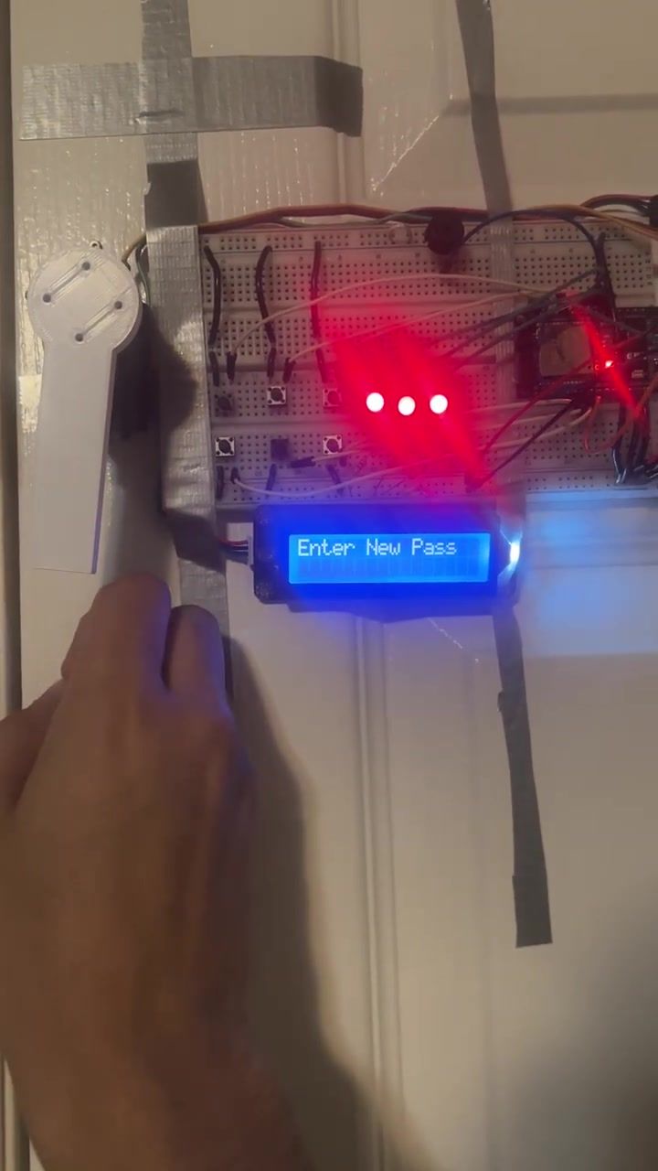 The LCD reading Enter New Pass with a finger over the keypad.